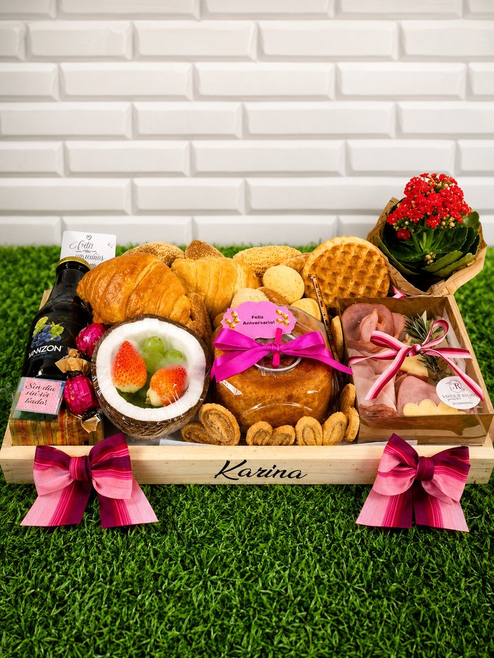 Cesta de café da manhã personalizada em caixa de madeira gravada Karina, com bolo e laço rosa, croissants, waffle, suculenta de flores vermelhas, suco de uva e frutas
